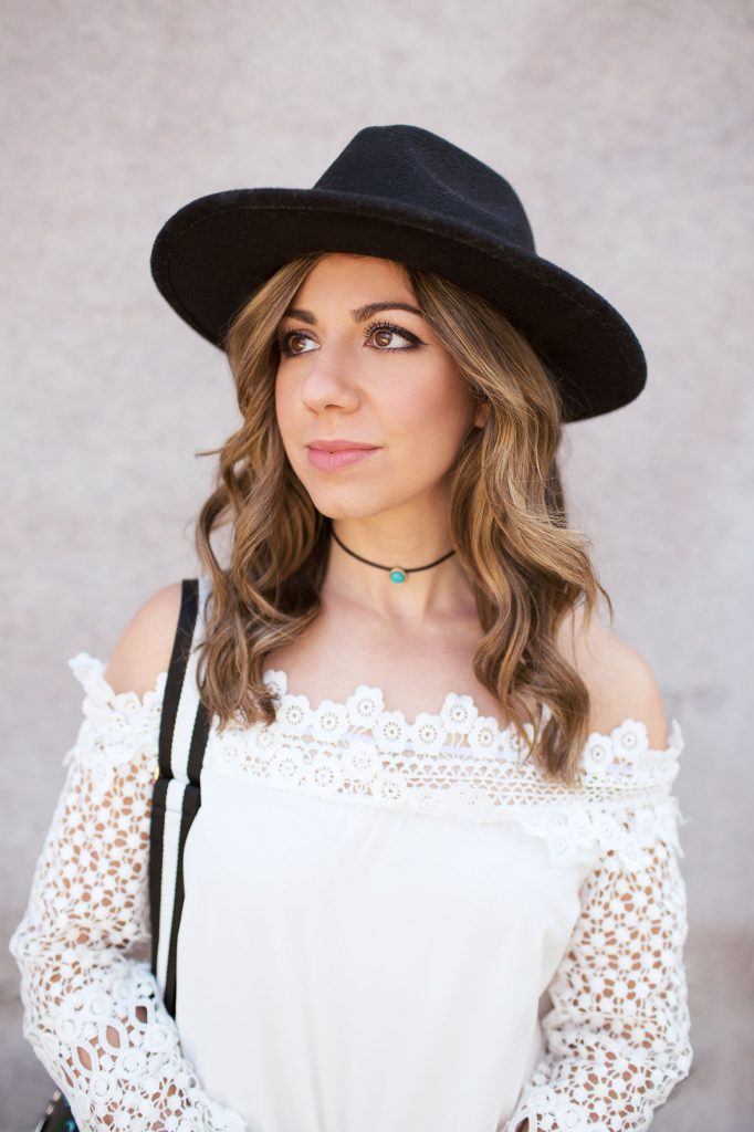 Lifestyle Blogger Roxanne of Glass of Glam wearing a SheIn lace off the shoulder top, Express denim, Justfab Shoes, Zaful bag, and a feathered fedora