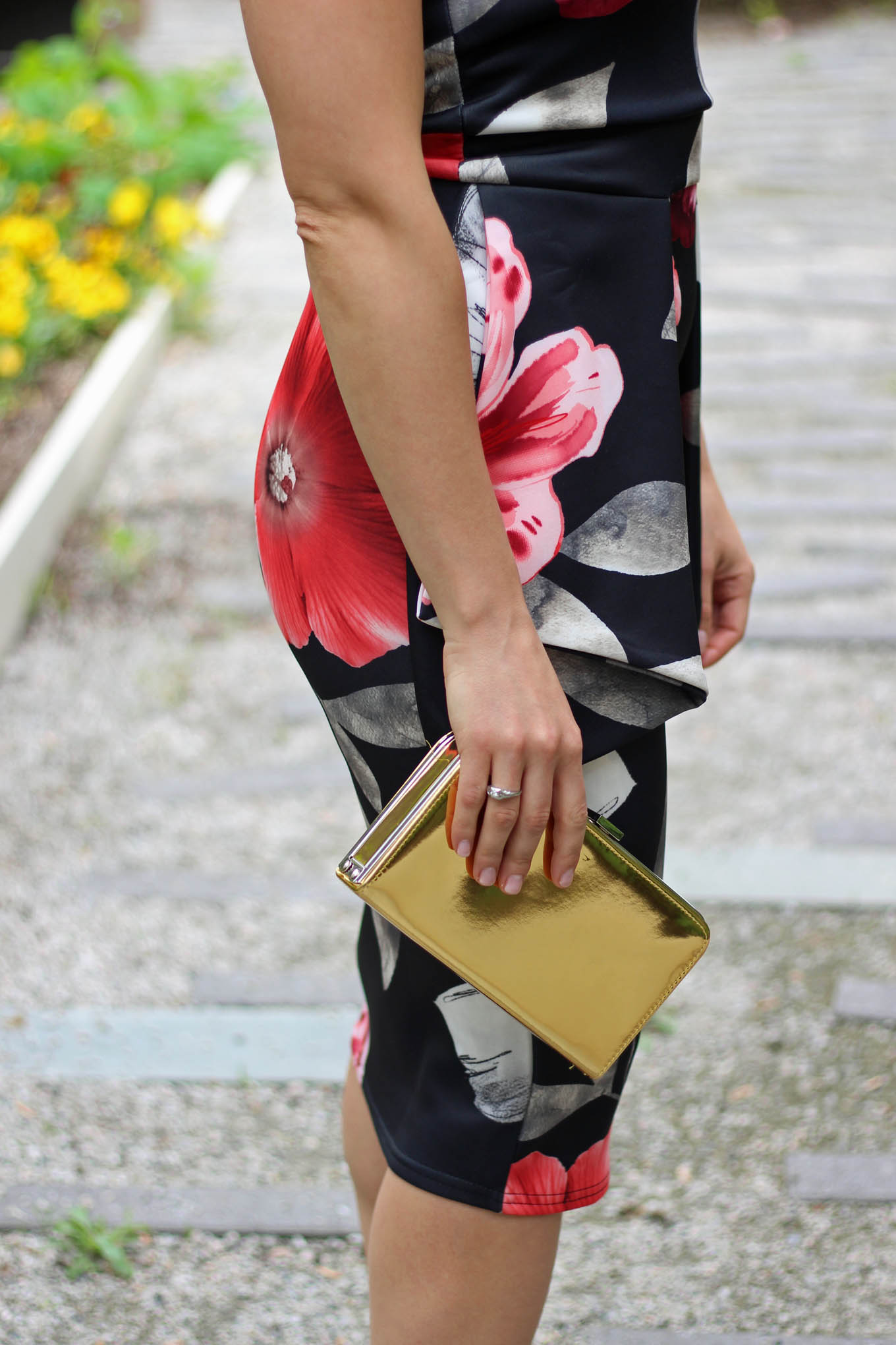 Lifestyle Blogger Roxanne of Glass of Glam wearing a floral Boohoo dress and gold box clutch
