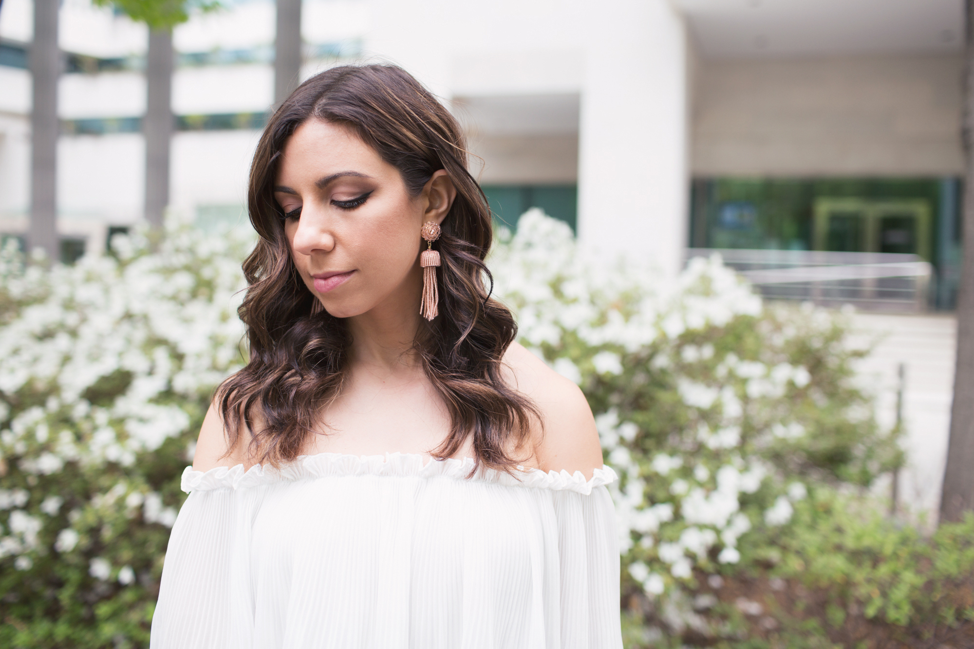 Lifestyle blogger Roxanne of Glass of Glam wearing a Goodnight Macaroon off the shoulder top, Old Navy denim, Lisi Lerch tassel earrings, and a silk scarf