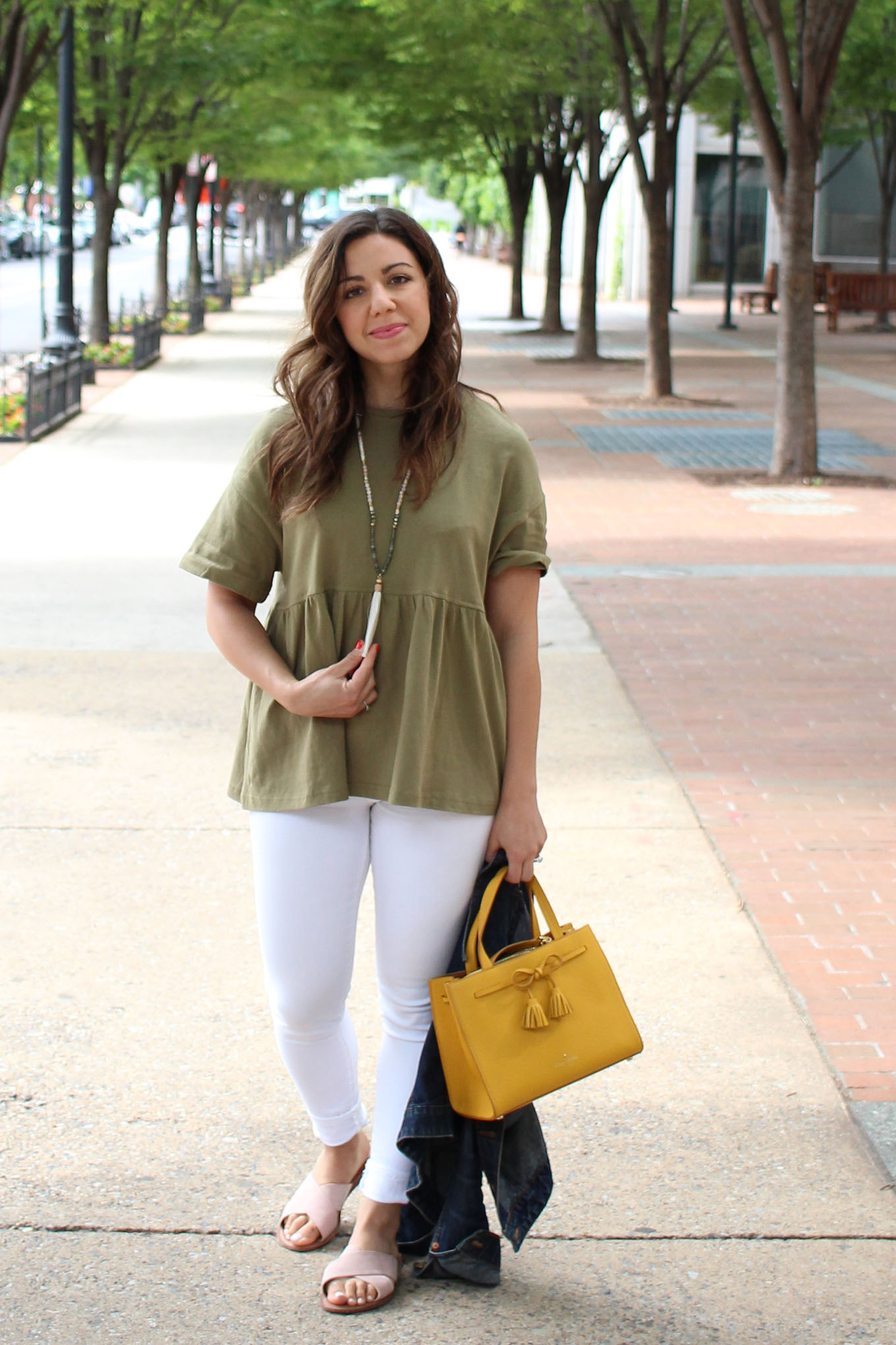Lifestyle Blogger Roxanne of Glass of Glam wearing an army green peplum top, white denim, kate spade bag, and pink slides