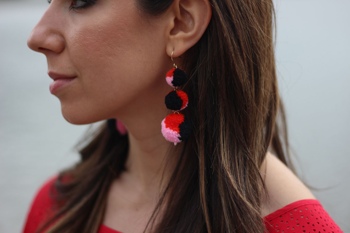 Lifestyle blogger Roxanne of Glass of Glam wearing a red Cuddy Studios top, Baublebar earrings, and Old Navy Denim