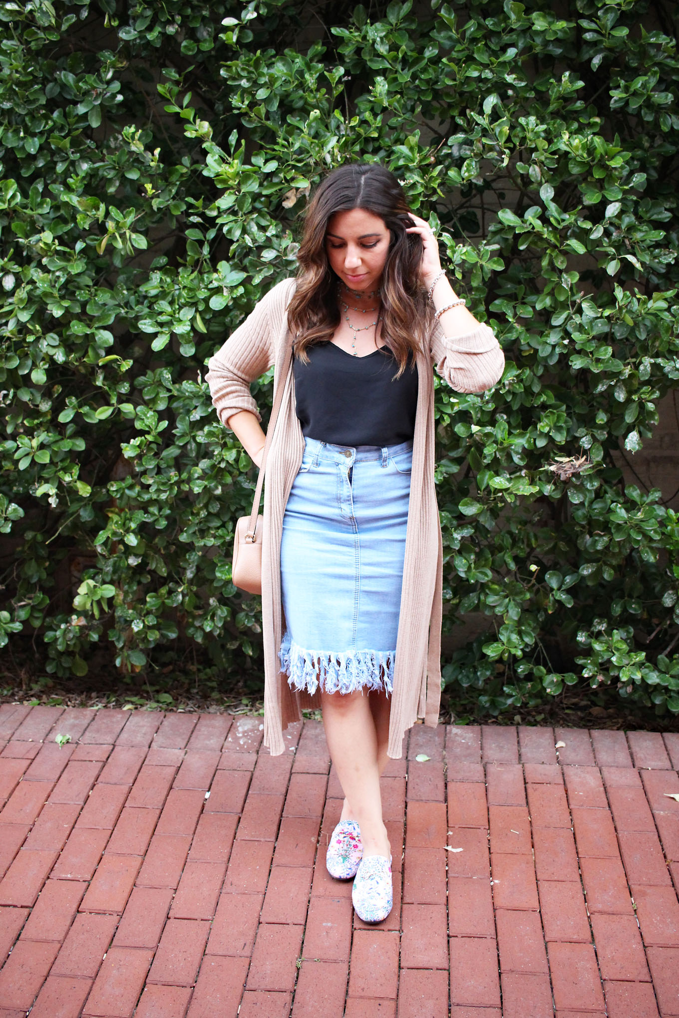 Lifestyle blogger Roxanne of Glass of Glam wearing a Justfab duster cardigan, distressed denim skirt, and pink Gucci dupes