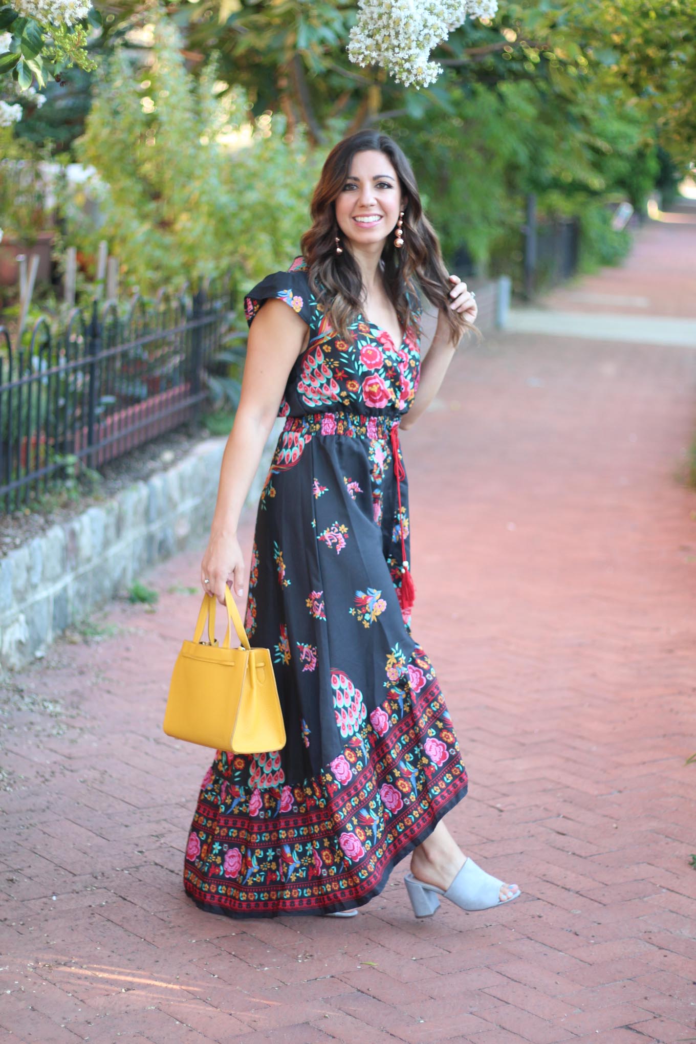 Lifestyle blogger Roxanne of Glass of Glam wearing a navy blue floral high low dress, Kate Spade bag, and Baublebar Earrings