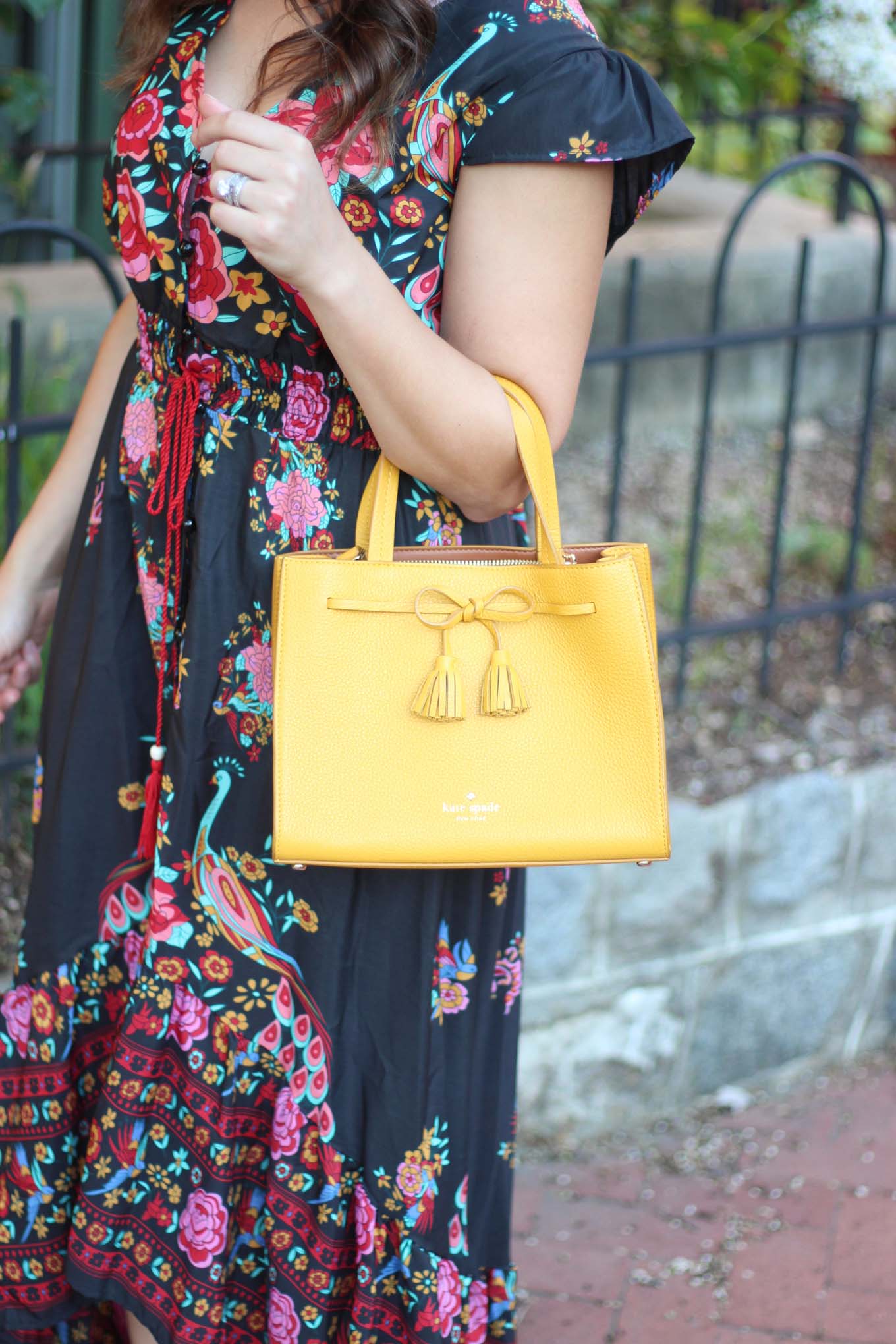 Lifestyle blogger Roxanne of Glass of Glam wearing a navy blue floral high low dress, Kate Spade bag, and Baublebar Earrings