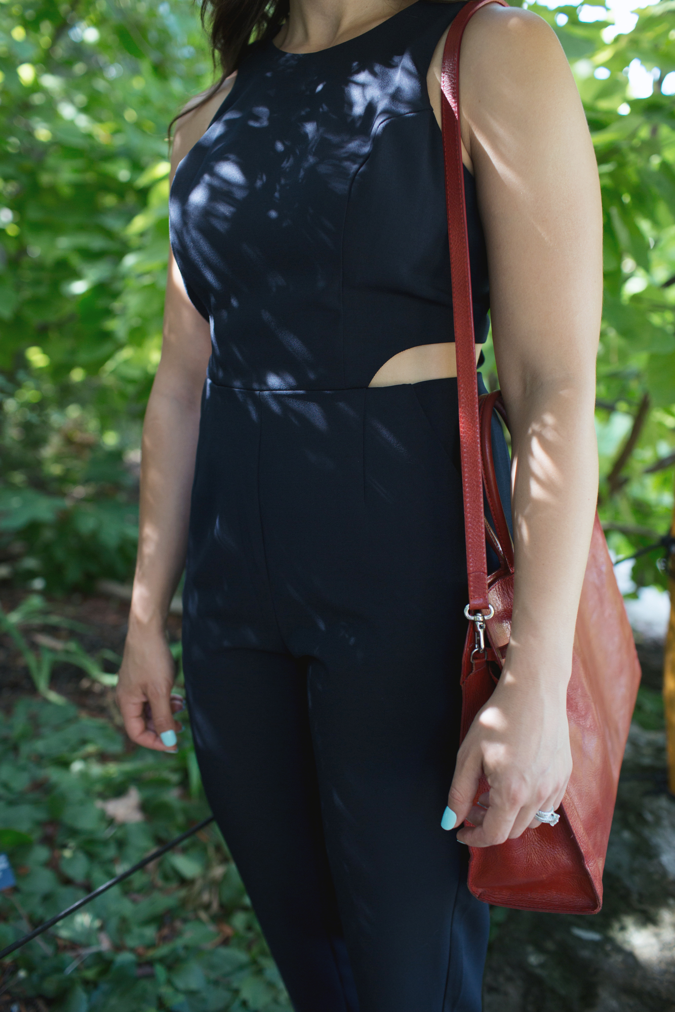Lifestyle blogger Roxanne of Glass of Glam' styling a navy jumpsuit and vintage Furla bag from Current Boutique
