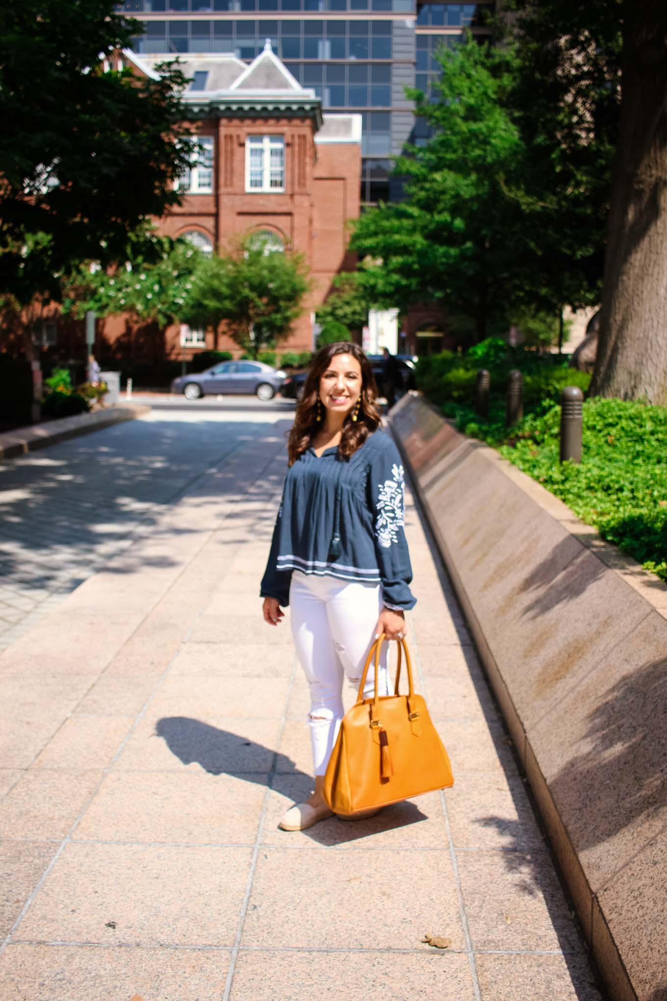 Lifestyle blogger Roxanne of Glass of Glam wearing a Tularosa blouse, Old Navy denim, 2Rivers tote, and Baublebar Earrings