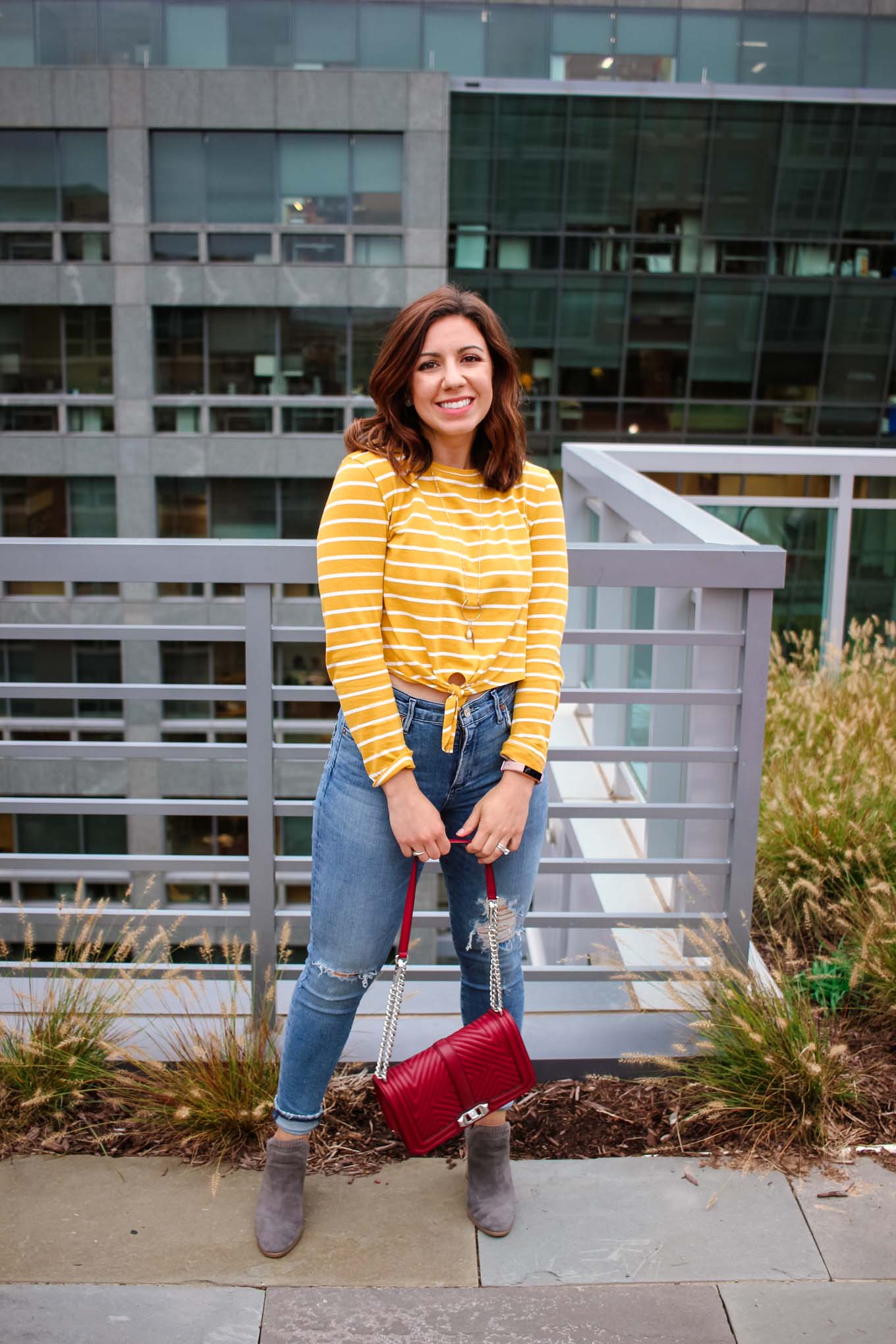 Lifestyle blogger Roxanne of Glass of Glam wearing a striped Shein crop top, A Gold E denim, and Vince Camuto Booties