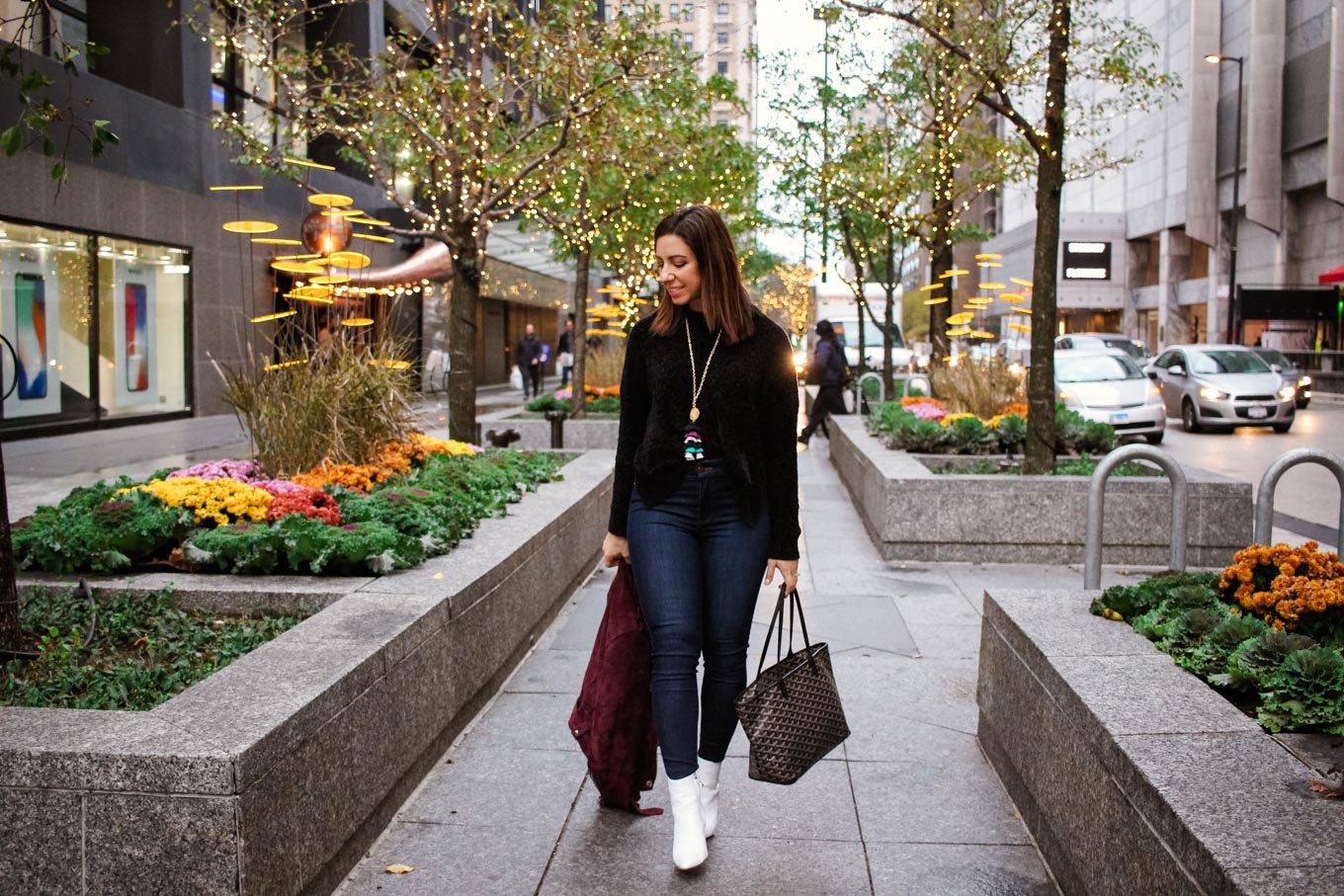 Lifestyle blogger Roxanne of Glass of Glam wearing a Target chenille sweater, Mott and Bow denim, white booties, bauble bar tassel necklace, and a Goyard bag