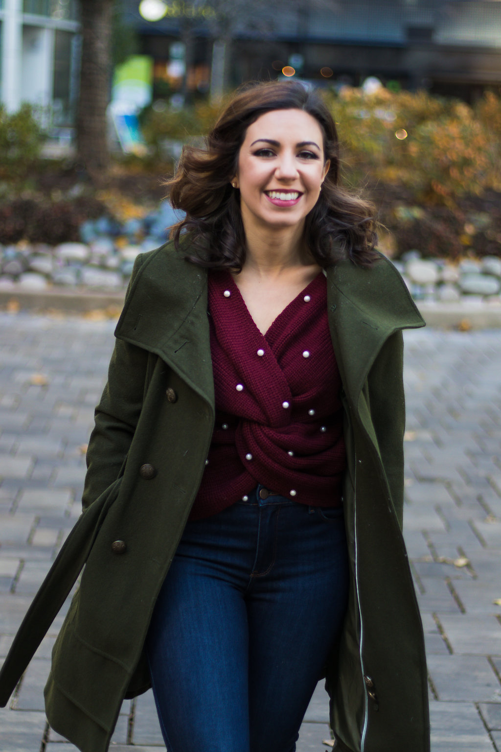 Lifestyle blogger Roxanne of Glass of Glam wearing a pearl burgundy sweater, green military jacket, Mott + Bow denim, and leopard booties