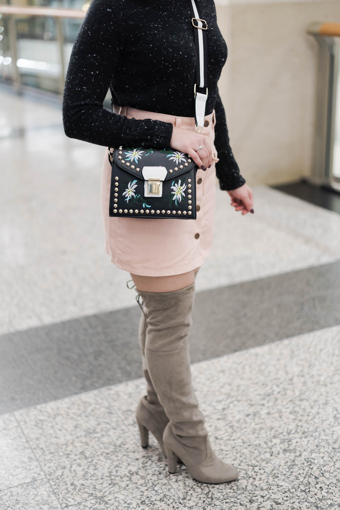 Lifestyle blogger Roxanne of Glass of Glam wearing a MINKPINK denim skirt, otk boots, a Madewell sweater, pom hat, and a rivet crossbody bag