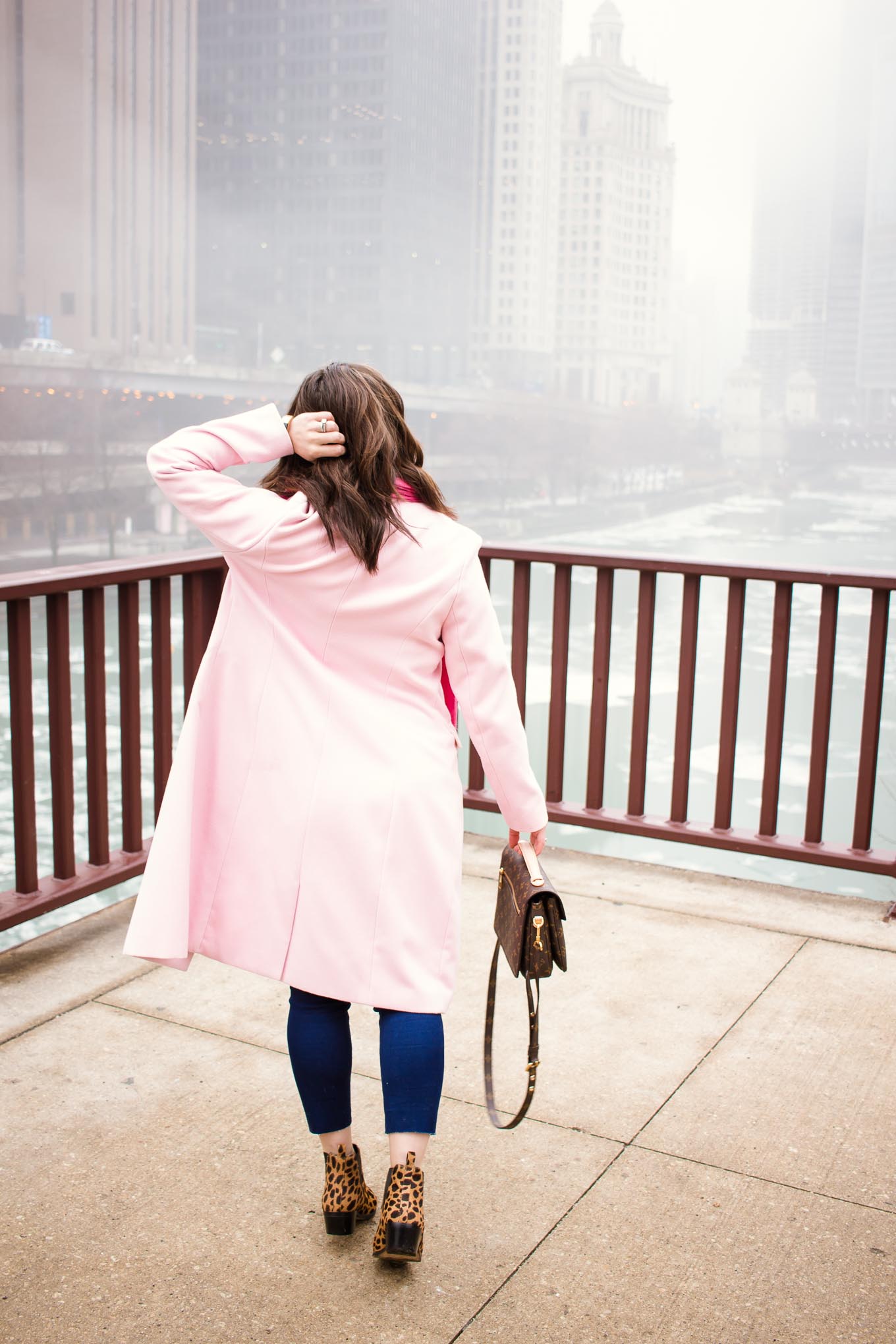 Lifestyle blogger Roxanne of Glass of Glam wearing a Factory-Fashion denim and top, a pink coat, Louis Vuitton Pochette Metis bag, Vince Camuto booties, and Grande Cosmetics lipstick