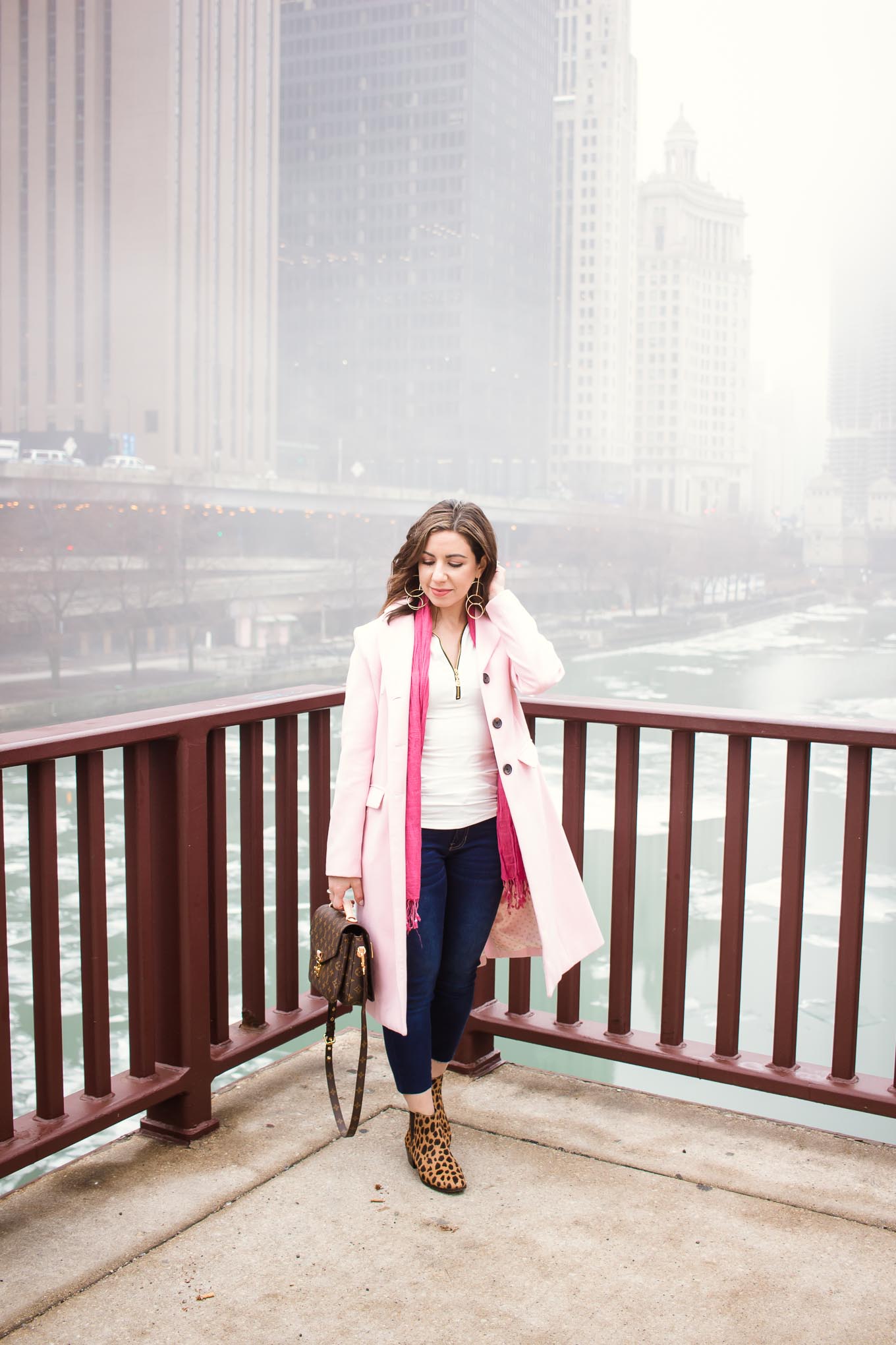 Lifestyle blogger Roxanne of Glass of Glam wearing a Factory-Fashion denim and top, a pink coat, Louis Vuitton Pochette Metis bag, Vince Camuto booties, and Grande Cosmetics lipstick