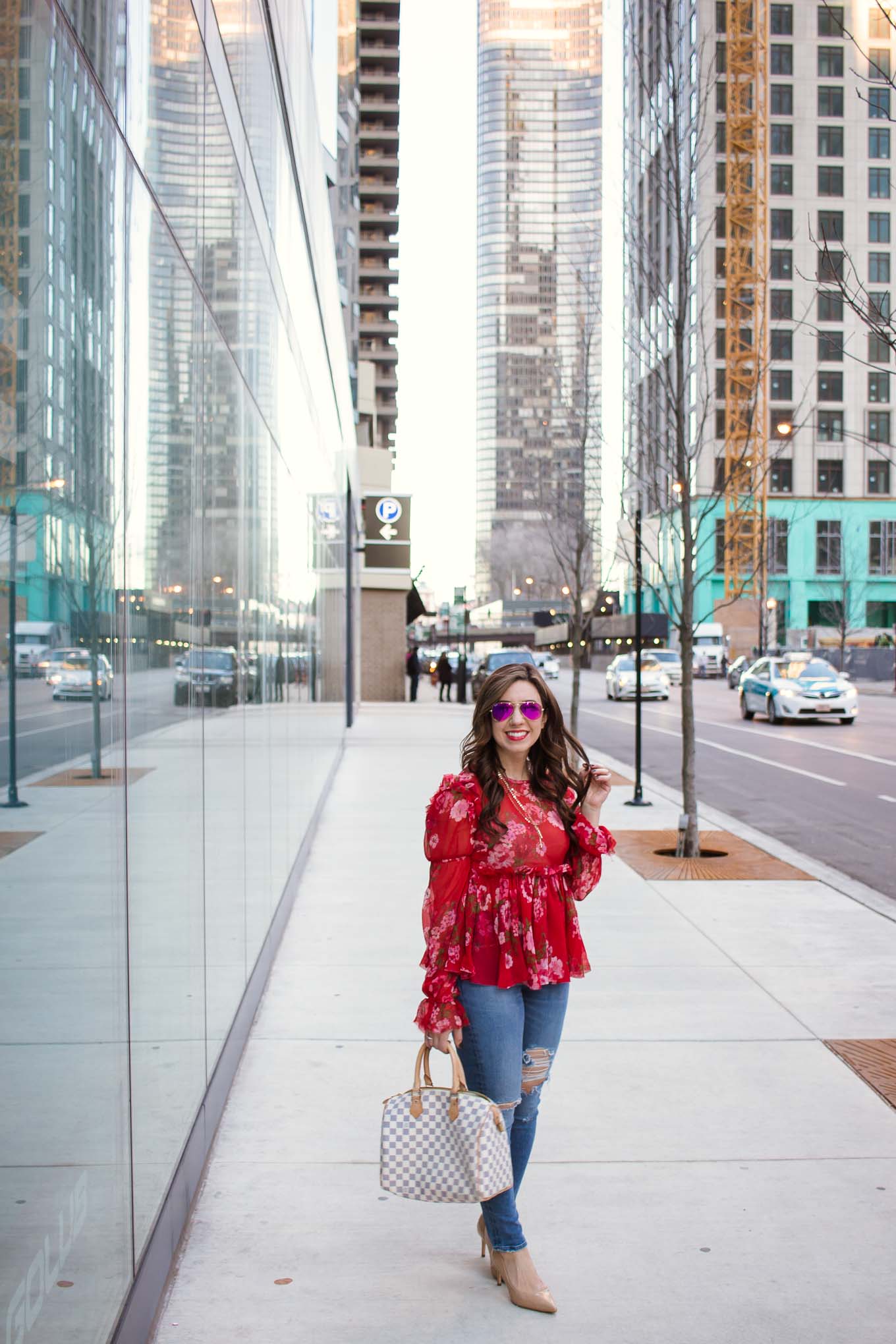 Lifestyle blogger Roxanne of Glass of Glam wearing an Asos ruffle top, Agolde denim, and Sam Edelman pumps