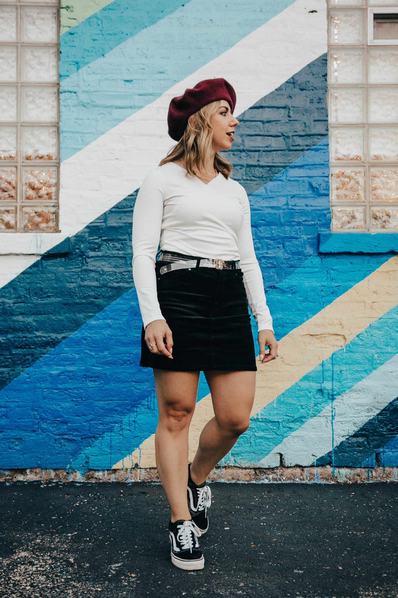 Stay truly informed featured by top US lifestyle blog, Glass of Glam: image of a woman standing in front of a rainbow wall wearing an H&M corduroy skirt, a SheIn bodysuit, Vans Old Skool and a red beret