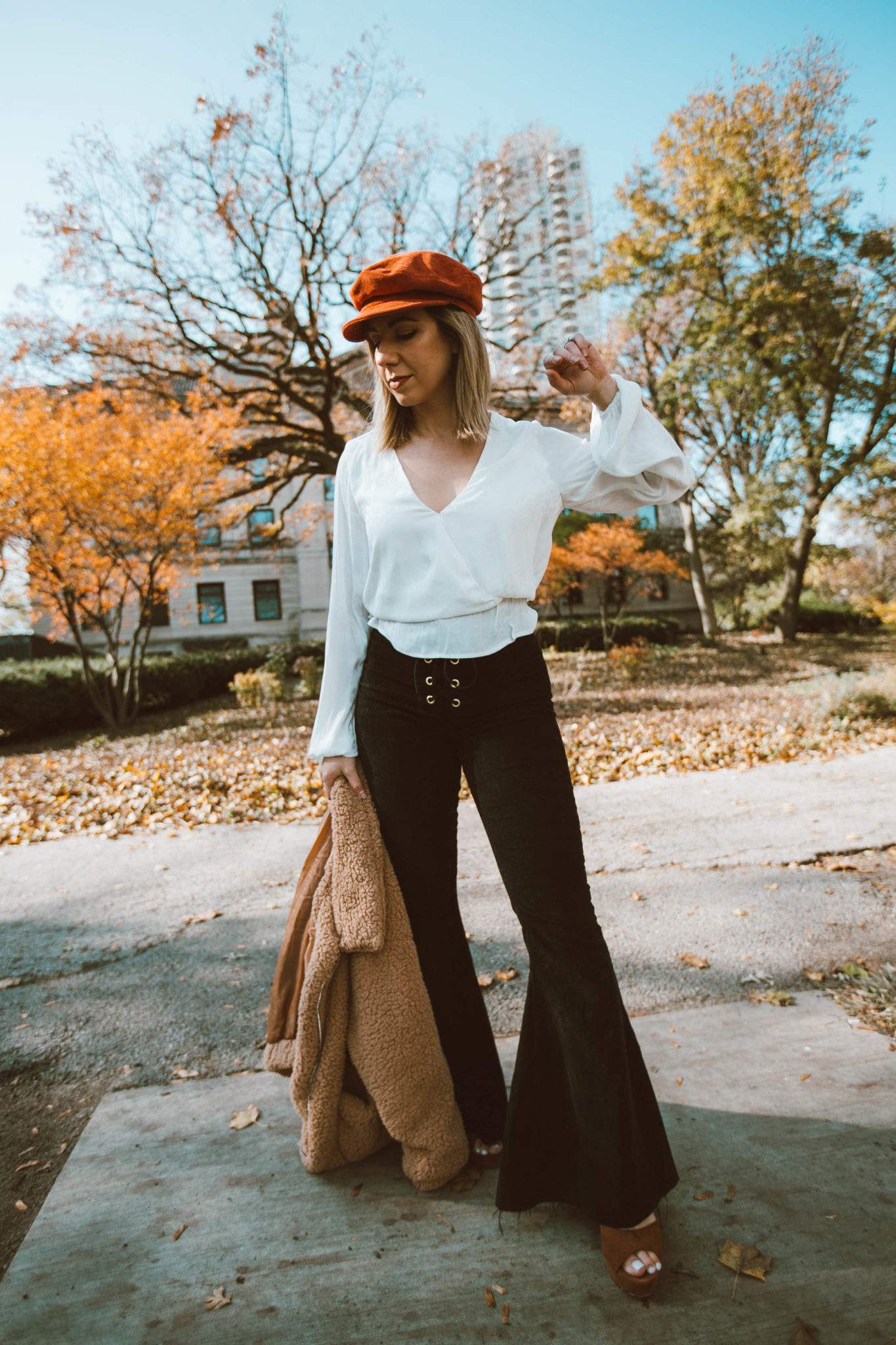  | Black Bell Bottoms and 70s style featured by top Chicago fashion blog, Glass of Glam: image of a woman wearing Show Me your MuMu black bell bottoms, Show me your mums white top,  SheIn faux fur teddy jacket, Steve Madden Lulla Sandals and a Brixton fiddle cap