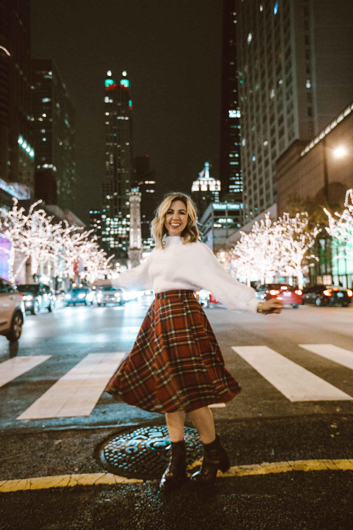 Best Chicago winter activities featured by top Chicago blog, Glass of Glam: picture of a woman in Chicago wearing a Happy Goat Lucky long puffer coat, Modcloth plaid skirt, Line & Dot sweater and Patricia Nash booties