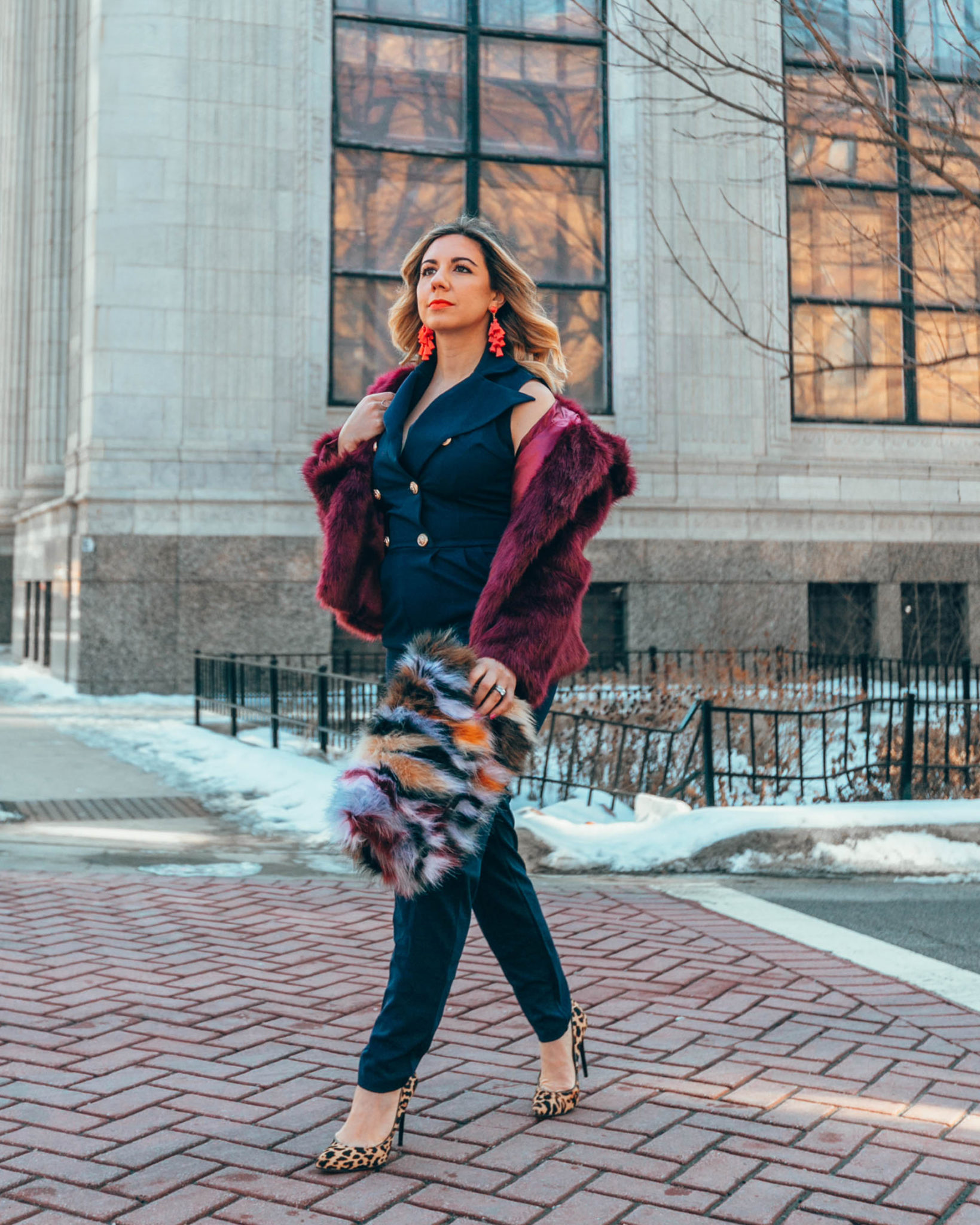 Blue jumpsuit styled for Spring by top US fashion blog, Glass of Glam: image of a woman wearing a SHEIN blue jumpsuit, SHEIN faux fur clutch bag, TOPSHOP faux fur coat, Sam Edelman leopard pumps, Baublebar earrings.