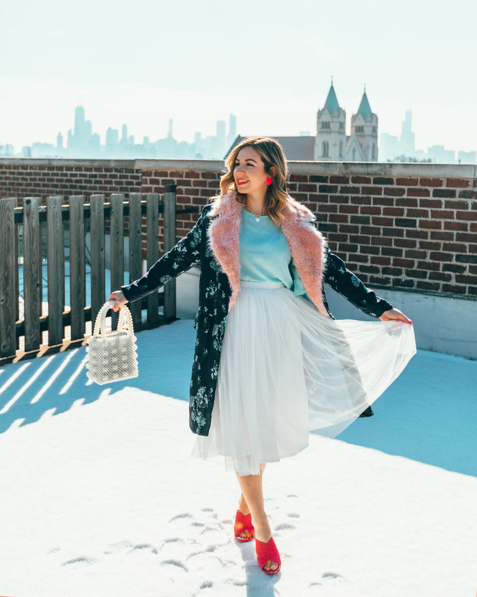 White tulle skirt styled by top US fashion blog, Glass of Glam: image of a woman wearing an ASOS white tulle skirt, SheIn Aqua top, Amazon pink sandals, Rent the Runway floral coat, BaubleBar heart pendant necklace, Baublebar heat earrings and an Amazon beaded handbag