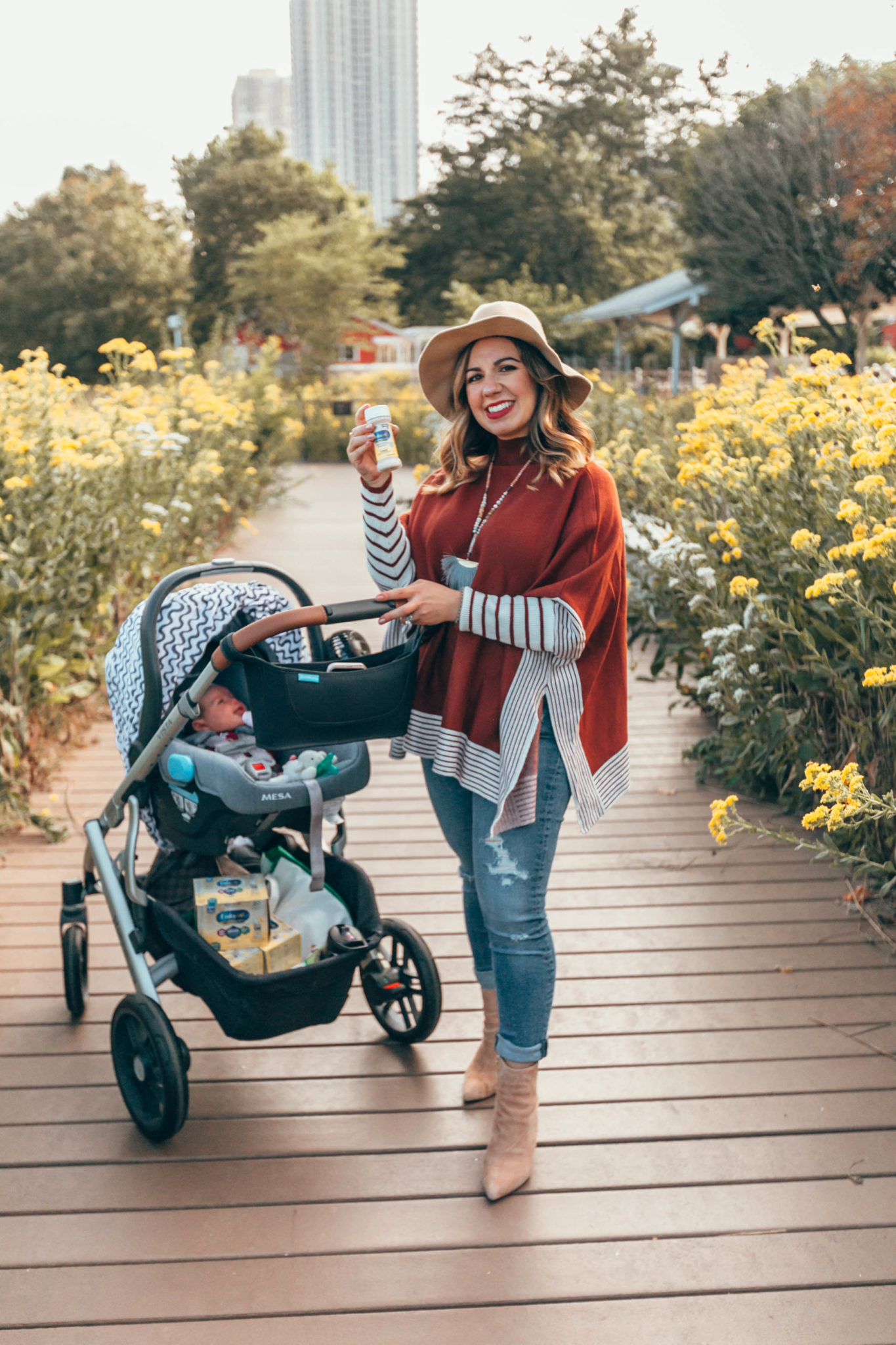 Enfamil NeuroPro Infant Formula Is My Baby Formula Choice by popular Chicago mom blog, Glass of Glam: image of a mom pushing her baby in a stroller outside and holding a bottle of Enfamil NeuroPro Infant Formula. 