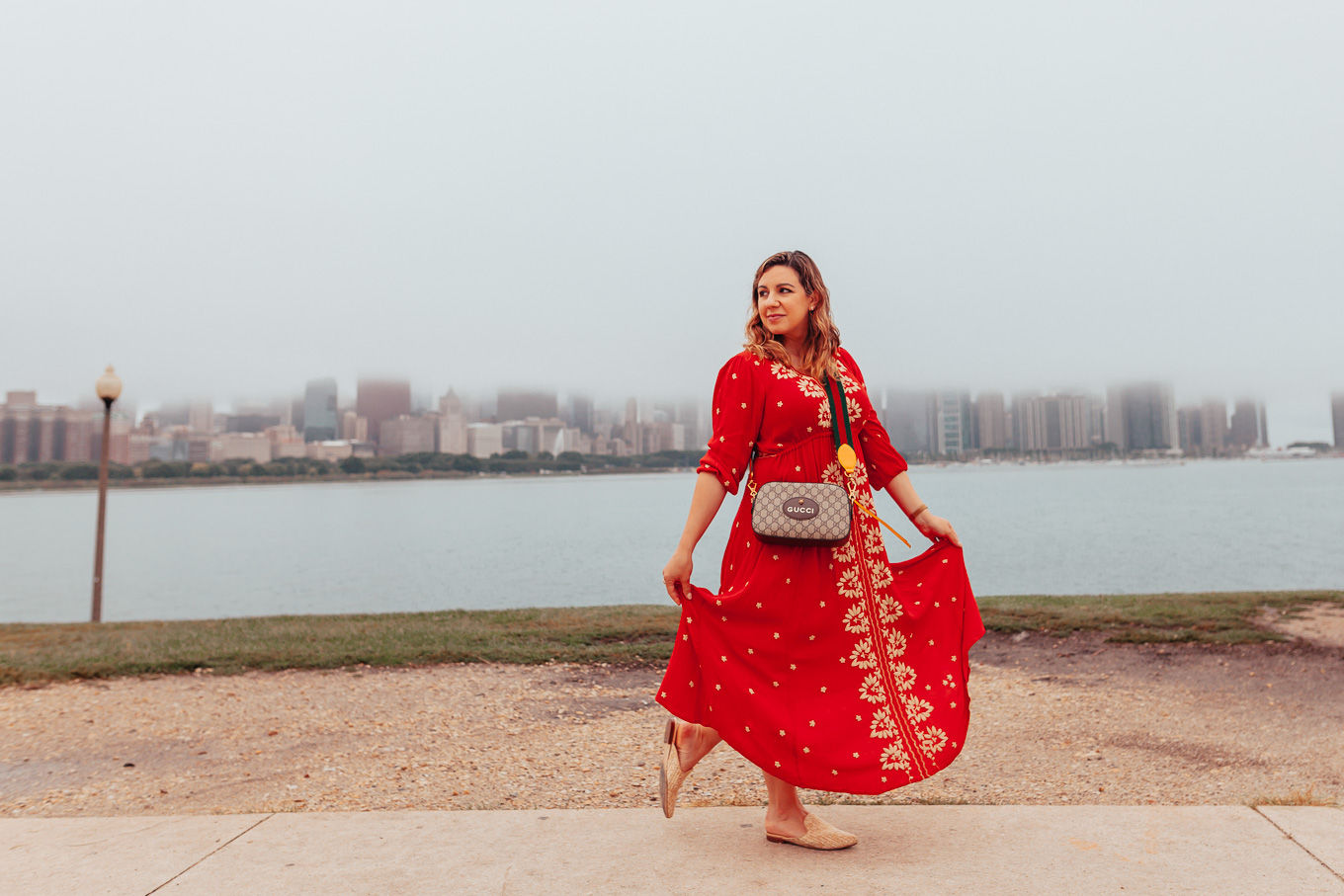 My New Mom Morning Routine by popular Chicago mom blog, Glass of Glam: image of a mom walking outside with her newborn baby and wearing an Anthropologie Embroidered Fable Midi Dress, STEVE MADDEN MATTIS MULE, Gucci GG Supreme messenger bag, and Little Me Leopard Footie. 