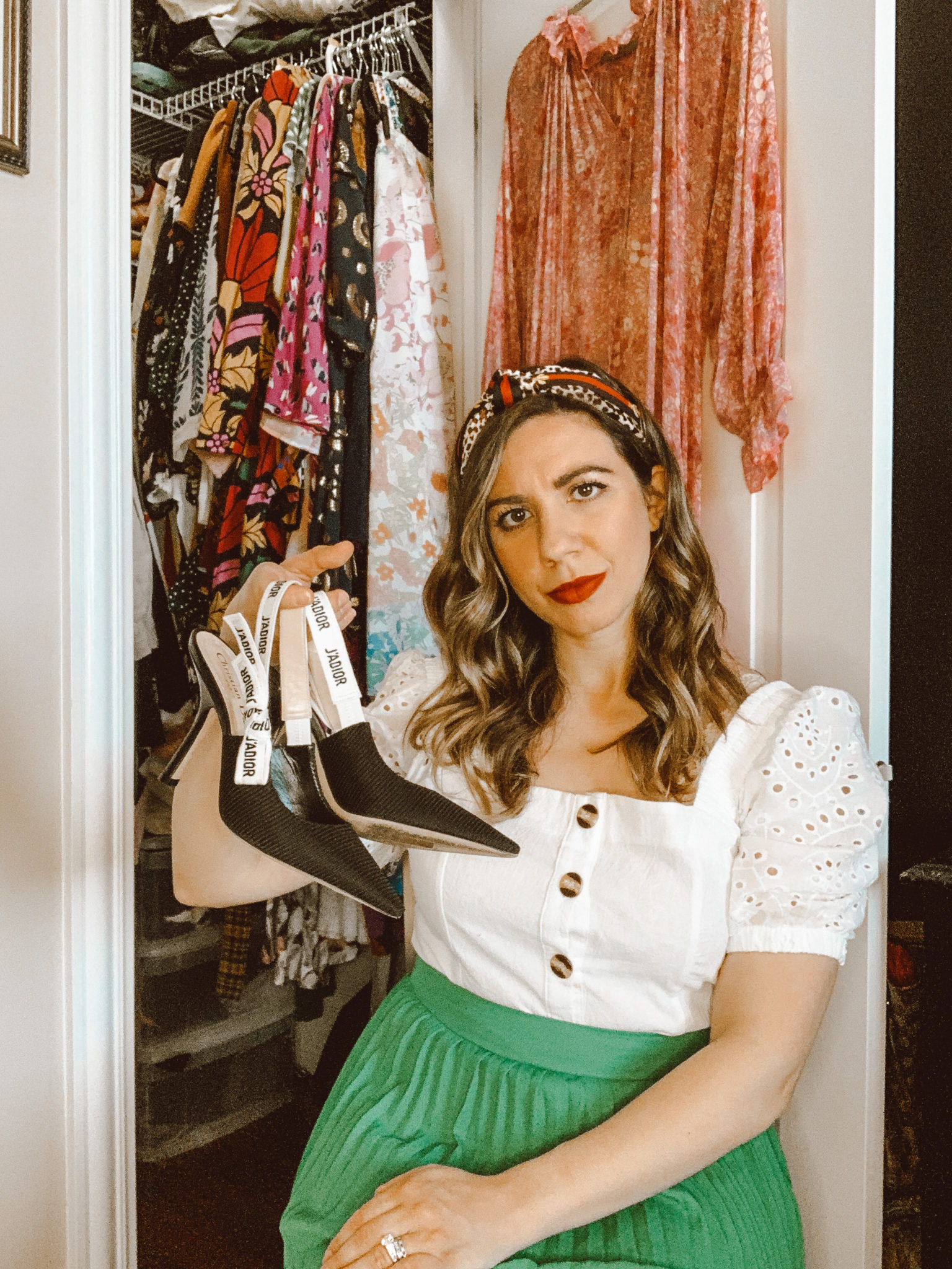 Missed Fashion Items by popular Chicago fashion blog, Glass of Glam: image of a woman sitting in her closet holding a pair of Dior J'ADIOR PUMP IN TECHNICAL CANVAS and wearing a SheIn Eyelet Embroidery Button Through Blouse, Nordstrom Pleated Midi Skirt HALOGEN®, Amazon leopard print knotted headband, and Lancome L'ABSOLU ROUGE HYDRATING LIPSTICK.