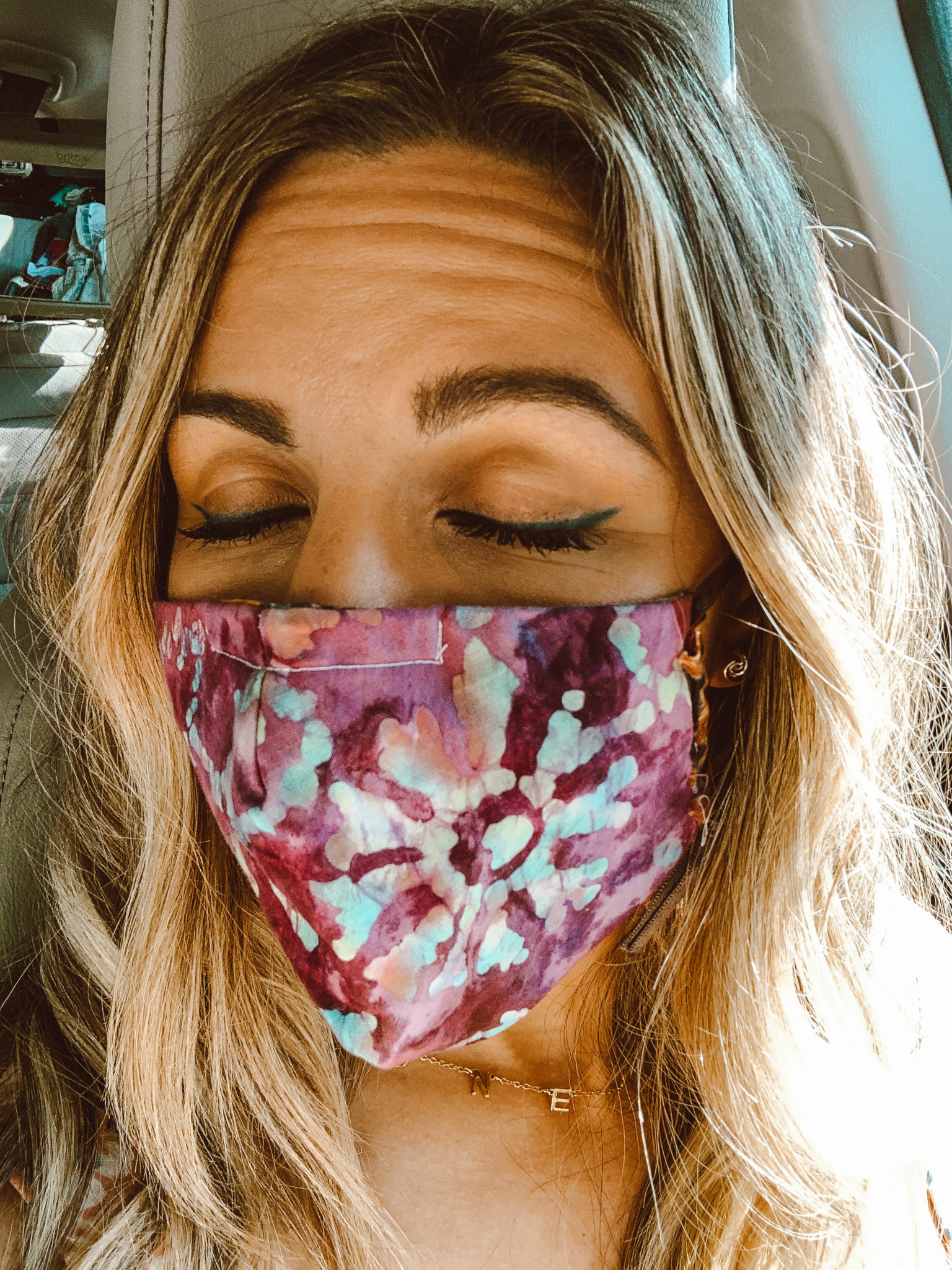 Eyebrow Tips by popular Chicago beauty blog, Glass of Glam: image of a woman with bushy eyebrows wearing a tie-dye face mask. 