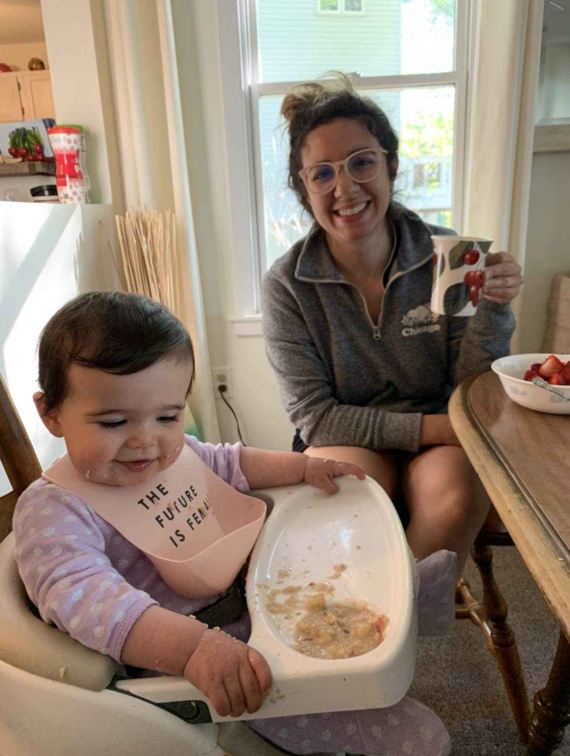 Traverse City by popular Chicago travel blog, Glass of Glam: image of a mom sitting next to her daughter who is sitting in a high chair and eating.