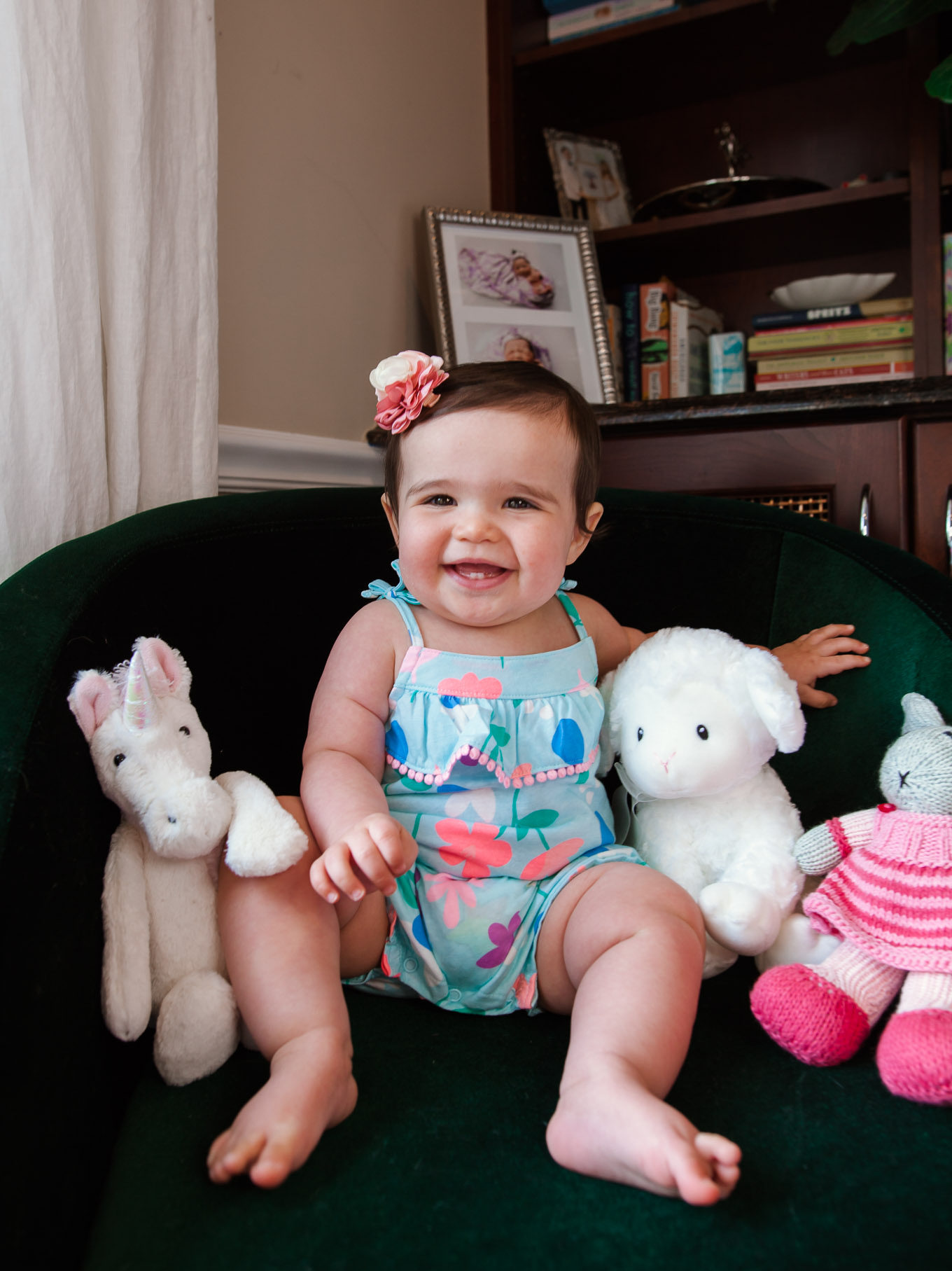 First Birthday by popular Chicago motherhood blog, Glass of Glam: image of 10 month old baby girl sitting with some stuffed animals.