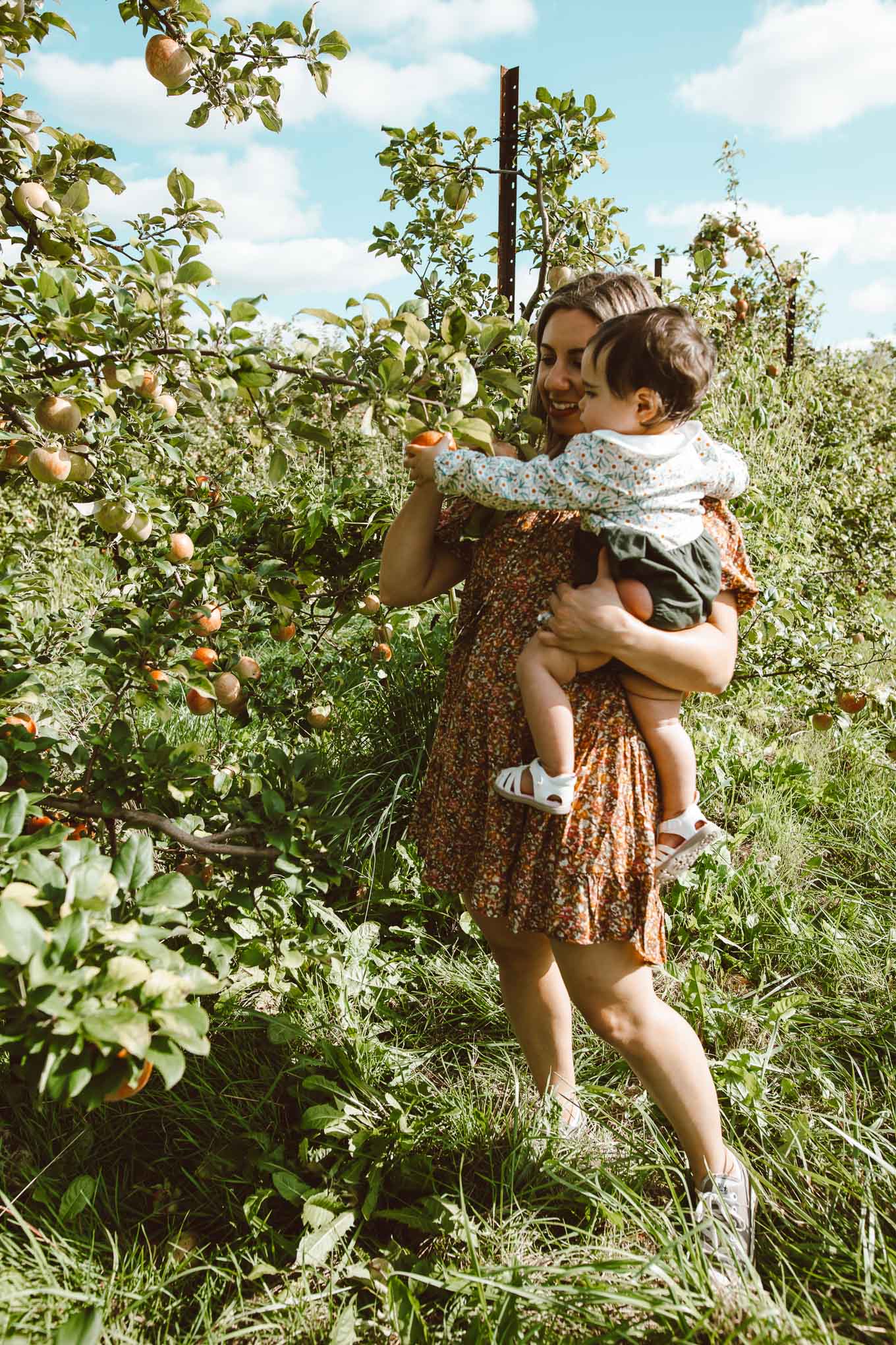 Apple Picking by popular Chicago lifestyle blog, Glass of Glam: image of a woman and her 1 year old daughter in a apple orchard and wearing a Target Women's Puff Short Sleeve Dress, Zappos Converse Chuck Taylor® All Star® Core Ox, and Amazon Simplee kids Baby Girl Romper.