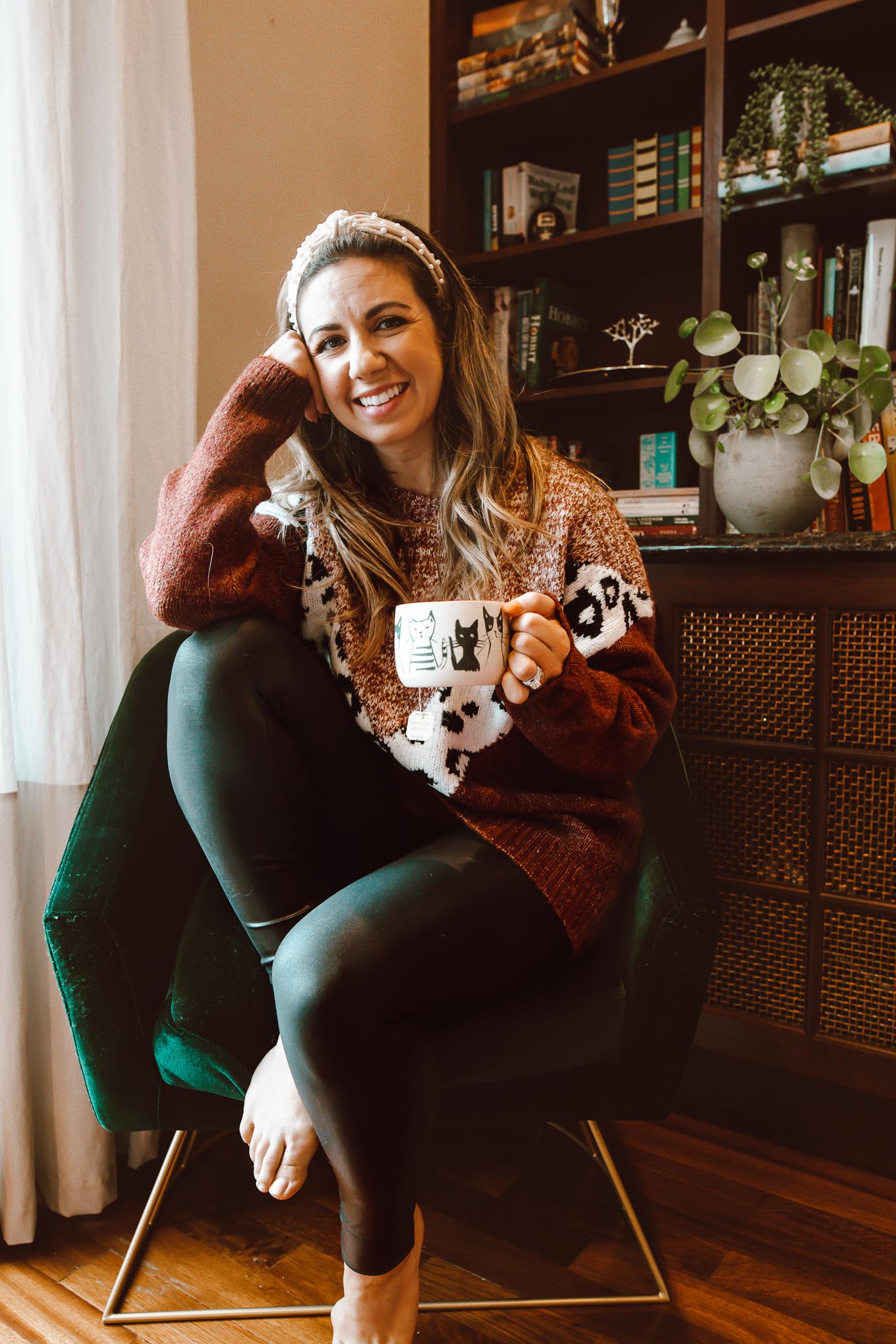 Pearl Headband by popular Chicago fashion blog, Glass of Glam: image of a woman sitting in a green velvet chair and wearing a Pink Lily Fascinating Stories Animal Print Burgundy Sweater, Nordstrom Spanx faux leather leggings, and Amazon Pearl Velvet Headband.
