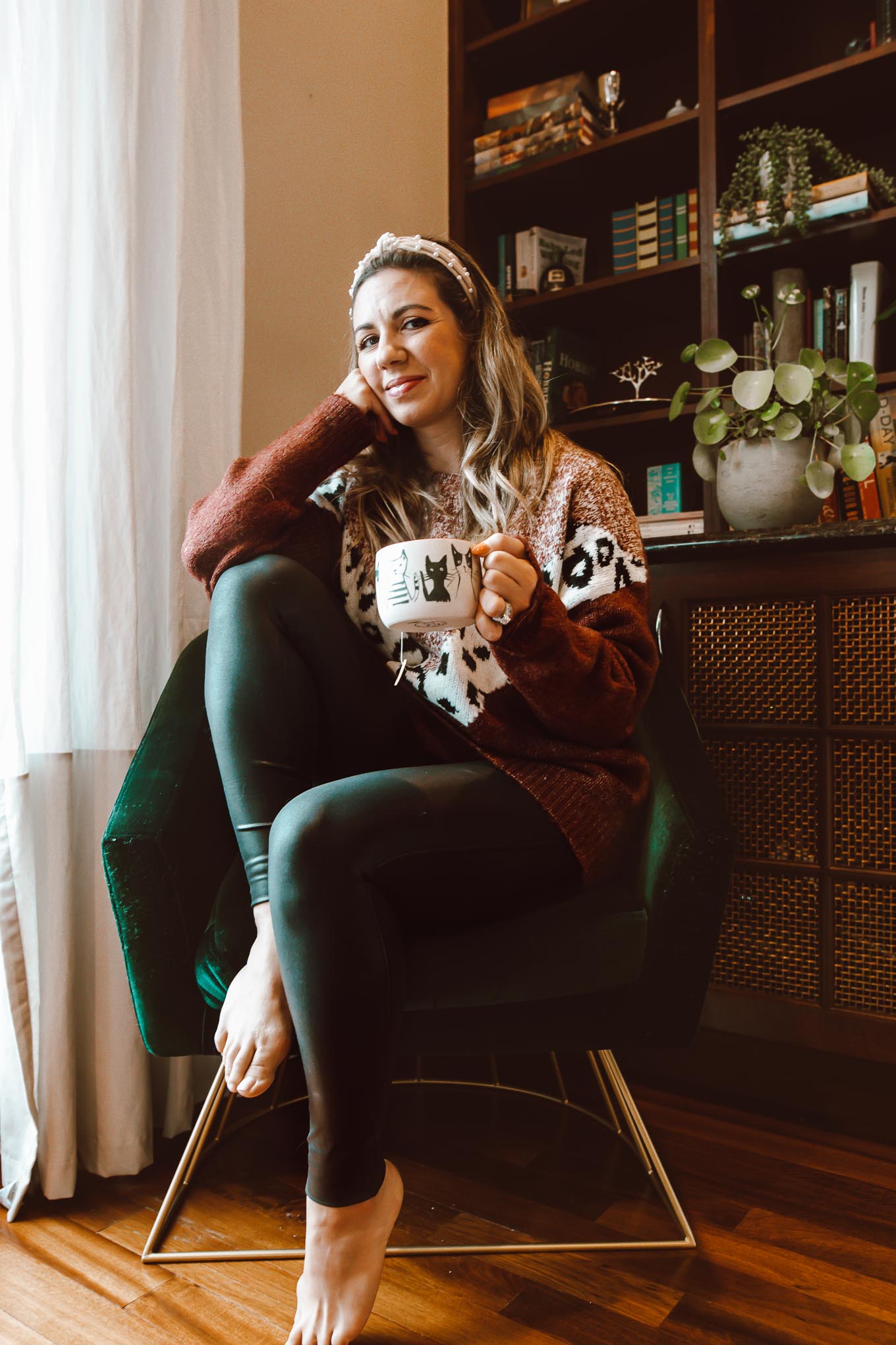 Pearl Headband by popular Chicago fashion blog, Glass of Glam: image of a woman sitting in a green velvet chair and wearing a Pink Lily Fascinating Stories Animal Print Burgundy Sweater, Nordstrom Spanx faux leather leggings, and Amazon Pearl Velvet Headband. 