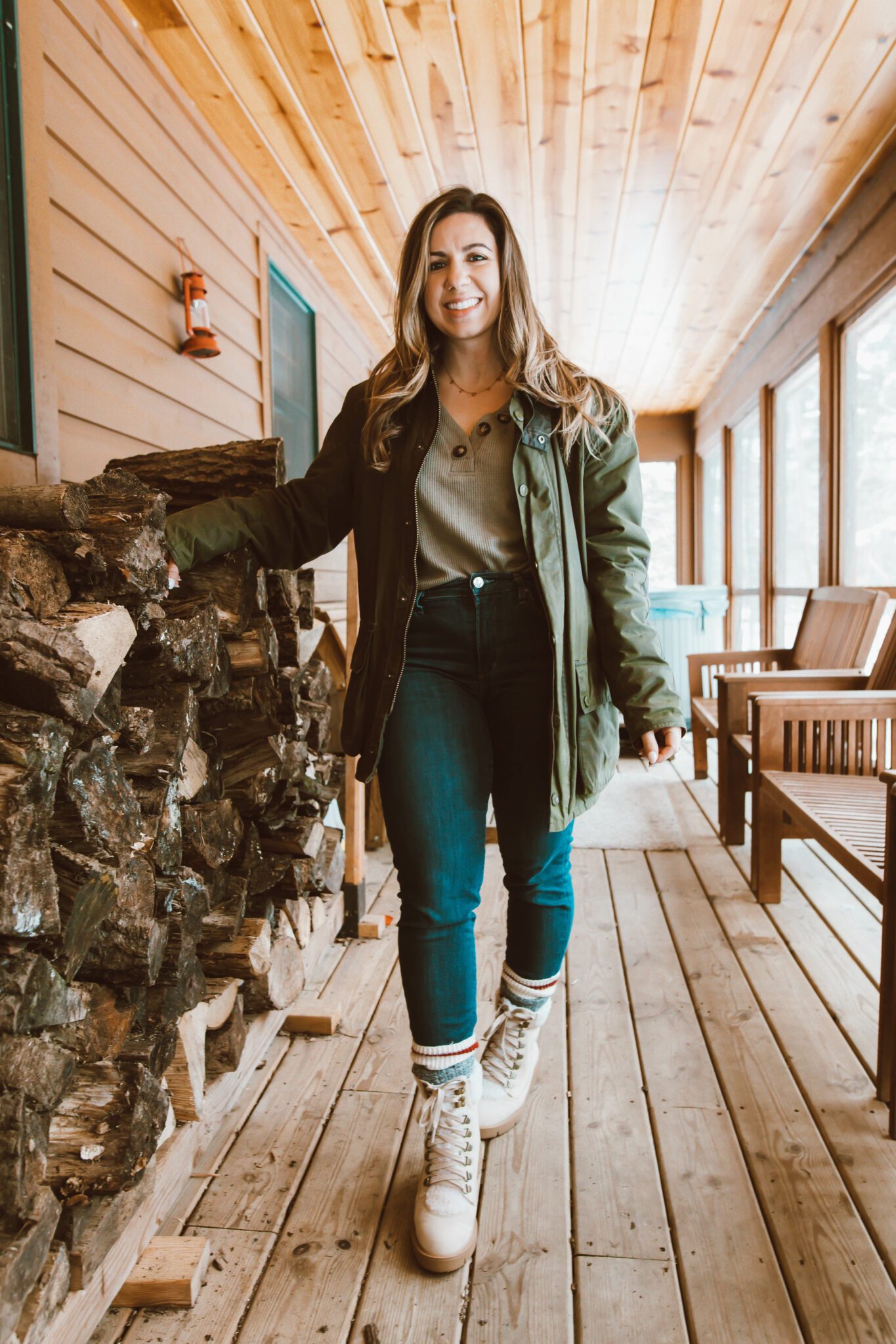 Olive Clothing by popular Chicago fashion blog, Glass of Glam: image of a woman standing on a cabin deck and wearing a waffle henley, Agolde denim, Just Fab boots, socks, Dan's Barbour Jacket