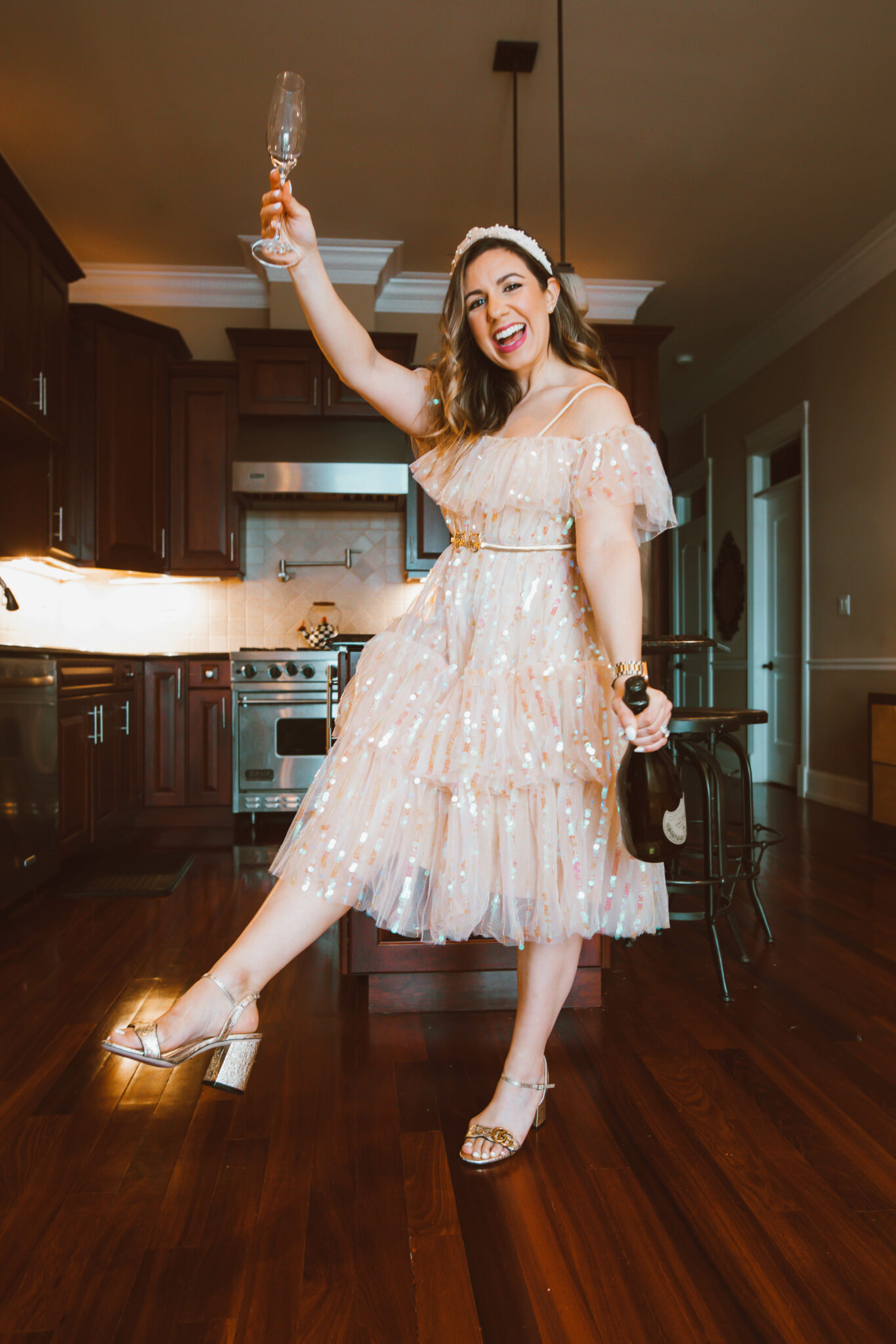 Party Dress by popular Chicago fashion blog, Glass of Glam: image of a woman holding a champagne flute and wearing a sequin party dress, pearl embellished knot headband, and Gucci block heel sandals. 