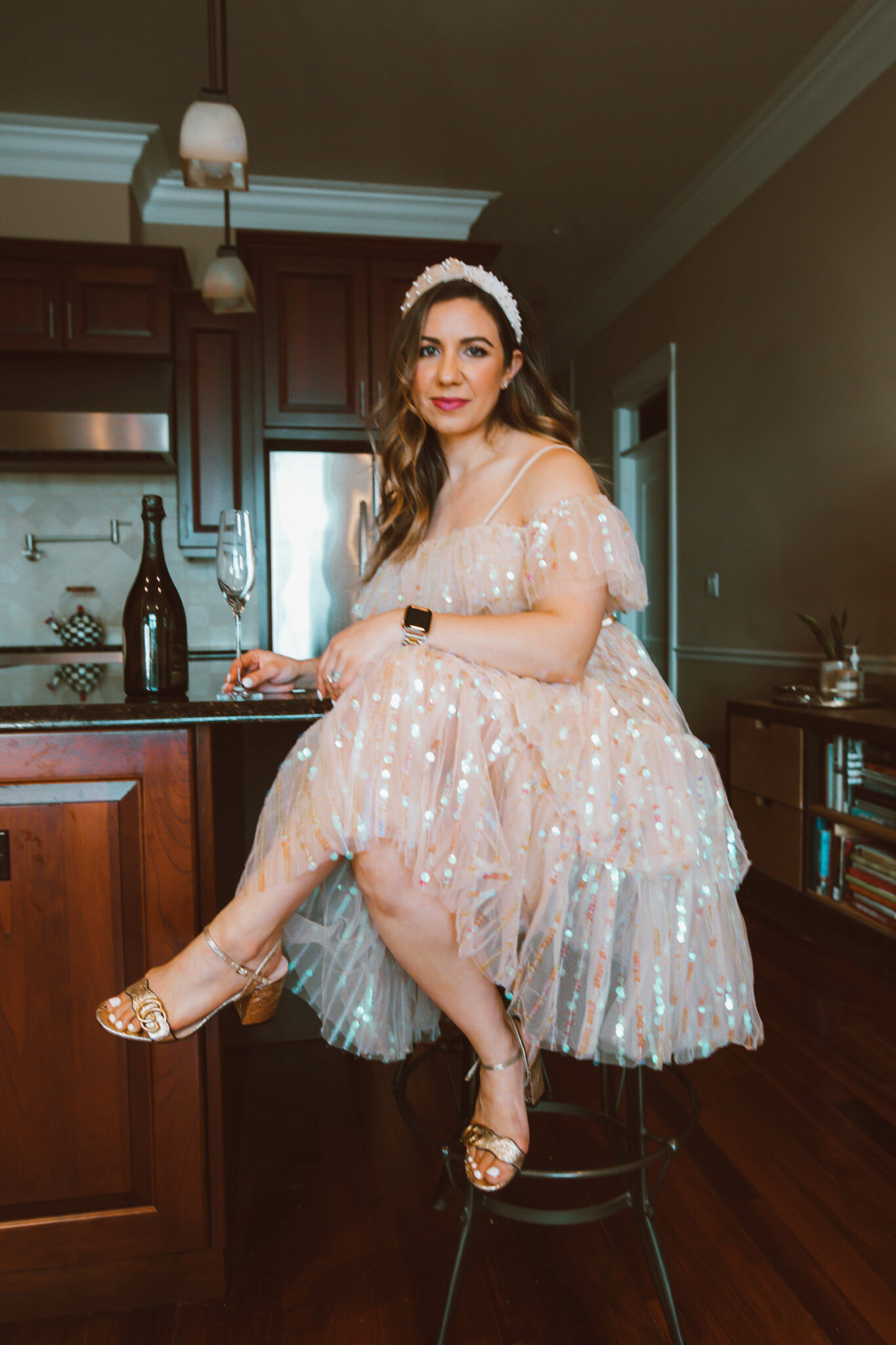 Party Dress by popular Chicago fashion blog, Glass of Glam: image of a woman holding a champagne flute and wearing a sequin party dress, pearl embellished knot headband, and Gucci block heel sandals.