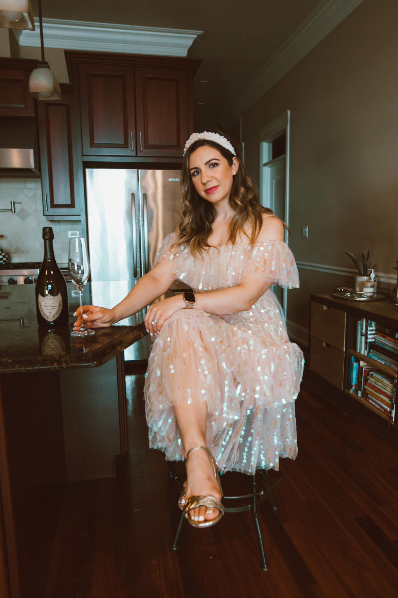 Party Dress by popular Chicago fashion blog, Glass of Glam: image of a woman holding a champagne flute and wearing a sequin party dress, pearl embellished knot headband, and Gucci block heel sandals. 