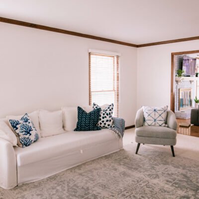 Thomasville Furniture by popular Chicago life and style blog, Glass of Glam: image of living room decorated with a white couch, blue, grey and white accent rug, grey armchair, and blue and white throw pillows.